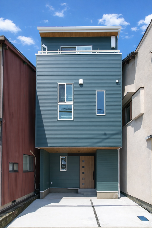 土地の幅4.8mに建つ緑色と茶色の自然な配色が和みを演出する家