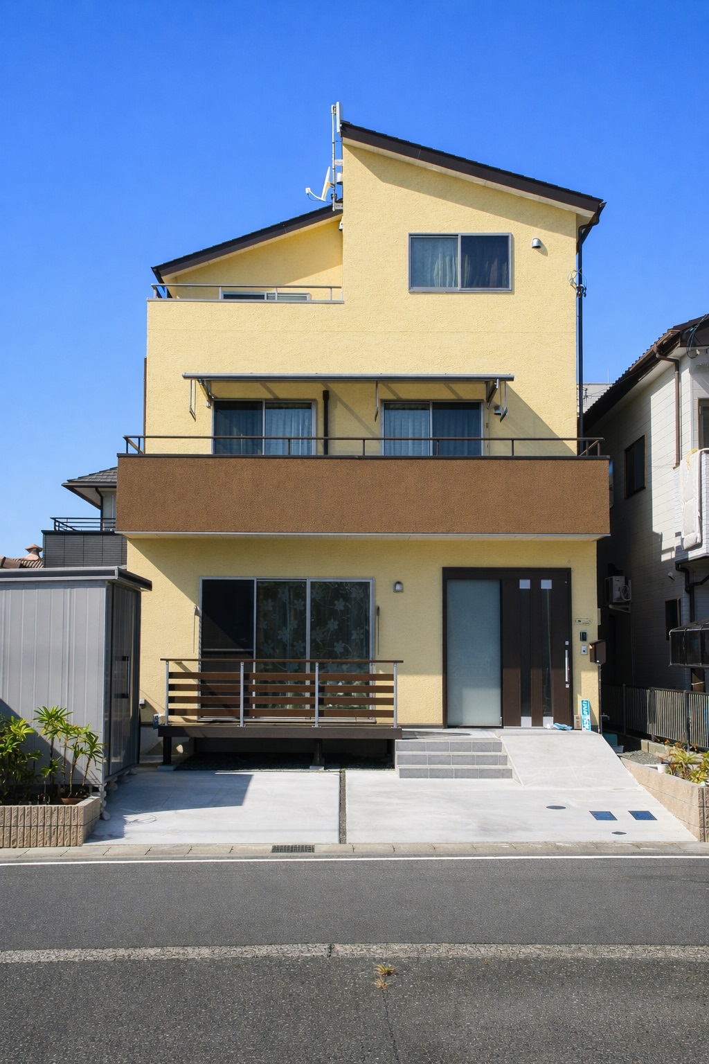 青空に映える陽だまりイエローの三階建て住宅！